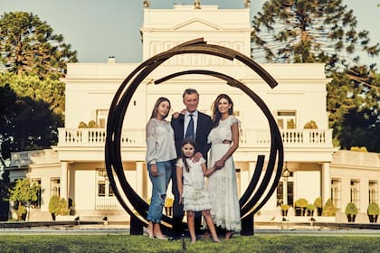 Mauricio, Juliana, Antonia y Valentina escoltados por una escultura circular hecha en hierro ubicada cerca del “espejo de agua” que hay frente a la residencia familiar.
