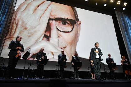 El compositor y director de orquesta italiano Andrea Morricone agradece los aplausos después de dirigir el conjunto de cuerdas Roma Sinfonietta interpretando "Tema de Deborah" en homenaje a su padre, Ennio Morricone, en la ceremonia de apertura del festival de Venecia