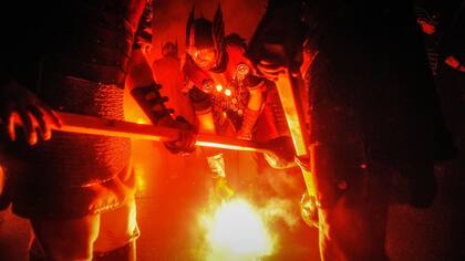Los participantes vestidos como vikingos prenden sus antorchas antes de la procesión.