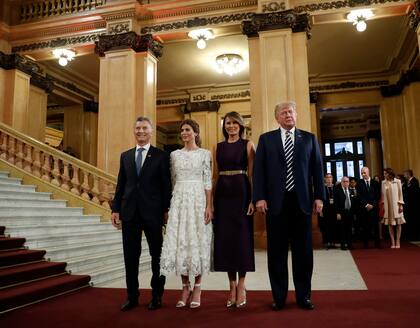 Melania Trump lució un vestido con largo coordinado con el de Juliana Awada. Fiel a su estilo, marcó su cintura con un cinturón dorado, en sintonía con sus stilettos.