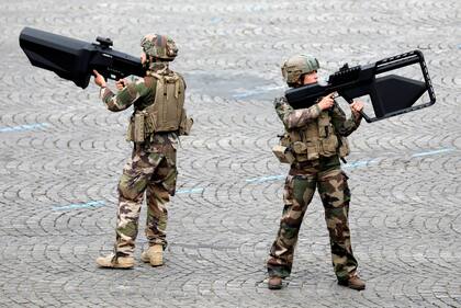 Soldados del ejército francés sostienen armas anti-drones durante el tradicional desfile militar del Día de la Bastilla en la Avenida Champs-Elysees en París