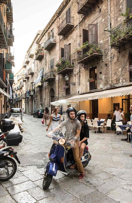 Una postal clásica de Palermo: las motos tipo Vespa por sus calles estrechas.