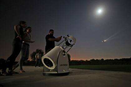 La gente se detiene a ver el eclipse lunar parcial a través de un telescopio en el Centro de Astronomía Al Thuraya en Dubai, Emiratos Árabes Unidos