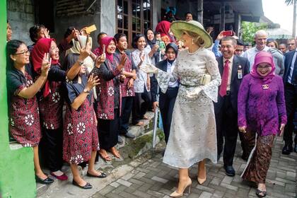 Durante la visita a la población de Kampong, cerca del Kraton o Palacio del Sultán, Máxima lució una creación de organza de Natan que figura como una de sus favoritas y se la vimos en anteriores ocasiones. La acompañó con una gran pamela de Fabienne Delvigne en fibra de banano.