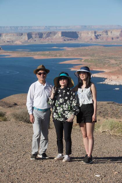 Una familia de turistas se toma una foto con lake Powell de fondo.