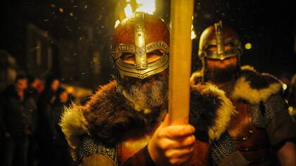 Los participantes vestidos como vikingos marchan en la procesión antes de quemar su nave en la culminación del festival Up Helly Aa