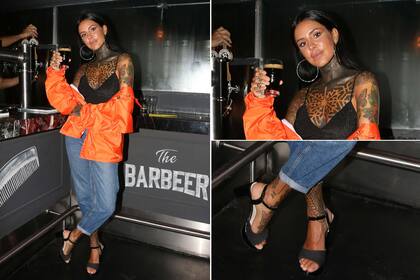 Orange vibes: Cande Tinelli, muy canchera con con una campera anaranjada, top, hoop earings, jeans y sandalias negras.