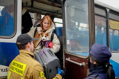 Refugiados ucranianos llegan en un autobús al centro de acogida en Mlyny, un antiguo centro comercial a pocos kilómetros de la frontera ucraniano-polaca en Korczowa