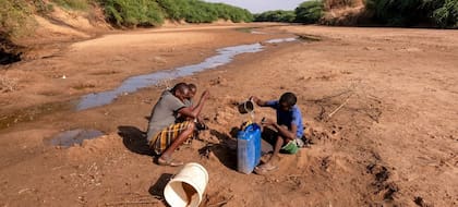08/04/2022 Un hombre y su hijo colectan agua del río Dollow, casi seco por la falta de lluvias, en Somalia.  La Organización Internacional para las Migraciones (OIM) ha advertido este viernes de que más de quince millones de personas del Cuerno de África se enfrentarán a la hambruna que provocará la sequía si no se toman medidas.  POLITICA UNICEF/SEBASTIAN