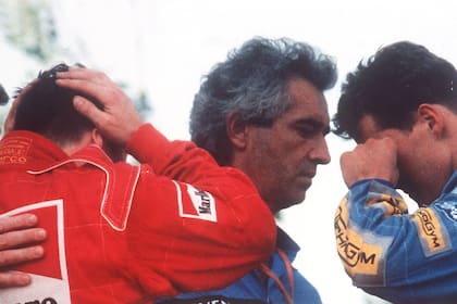 1 de mayo de 1994, el italiano Nicola Larini, con la cabeza en blanco, y el alemán Michael Schumacher, se limpia una lágrima de los ojos mientras habla con el director general de Benetton, Flavio Briatore, en el podio el accidente del Grand Prix de Fórmula Uno de San Marino en Imola, Italia