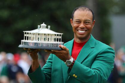 Tiger Woods sostiene el trofeo después de recibir la chaqueta verde por ganar el Torneo de golf Masters 2019 en el Augusta National Golf Club.