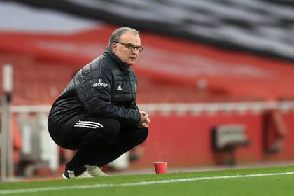 Marcelo Bielsa se pone en cuclillas en la línea de banda durante el partido entre el Arsenal y el Leeds United en el Emirates Stadium.