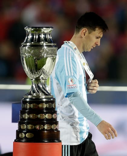 14 de julio de 2015: Lionel Messi pasa por el trofeo de la Copa América perdida ante Chile, en Santiago