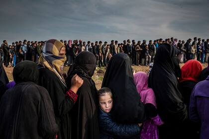 15 de marzo de 2017. Los civiles que se habían quedado en el oeste de Mosul durante la batalla para recuperar la ciudad se agrupan en fila para una distribución de ayuda en el barrio de Mamun. 