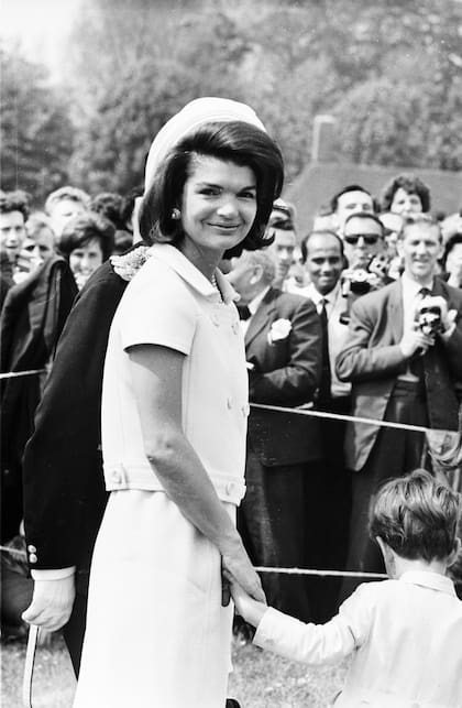 15 de mayo de 1965: Jacqueline Kennedy (1929-1994) asiste a la inauguración de un monumento a su esposo John F. Kennedy en Runnymede, Surrey, casi dieciocho meses después de su asesinato. Su pequeño hijo, John F. Kennedy Jr., le toma de la mano 