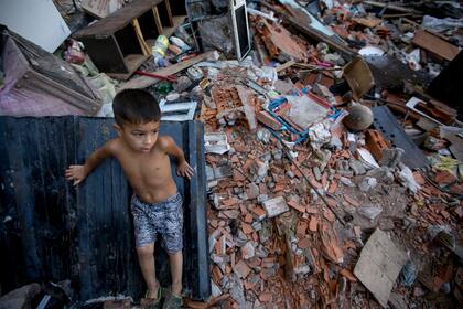19 de enero, 2018 – Uno de los hijos de Eleanora Vallejos juega en los escombros de las casas vecinas. Hace pocos meses, su hijo menor, de dos años, se electrocutó por la heladera de su casa una noche de tormenta.