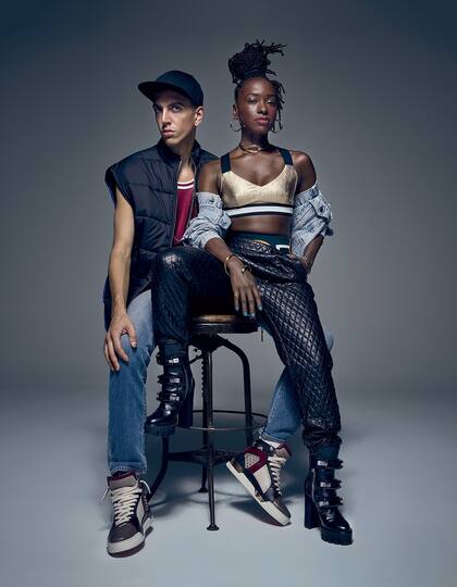 El: chaleco 3.1 Phillip Lim, camiseta Vintage Champion, jeans Levi’s, gorra H&M, zapatillas Christian Louboutin. Ella: campera de jean Levi’s, top deportivo No Ka ‘Oi, pantalones de cuero Breelayne, reloj Shinola, aros Bonheur, choker Pamela Love, pulsera Annelise Michelson, botas Dsquared2.