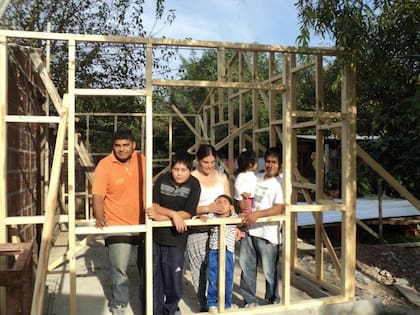 2013. La familia Longhi adentro de lo que todavía era solo madera y promesa. Con dos préstamos y sus propias manos, levantaron las paredes de su nuevo hogar.