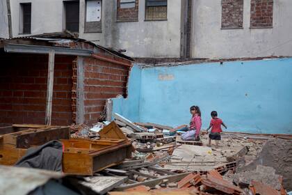 22 de noviembre, 2017 – Dos chicos juegan en los escombros de lo que solían ser casas. Descalzos, entre maderas y clavos, los padres se preocupan por el bienestar de sus hijos.