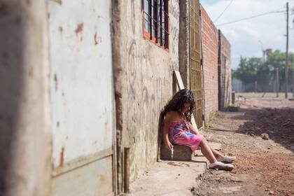 22 de noviembre, 2017 – La hija de Jorge Bernal, uno de los vecinos, juega con una jeringa llena de agua cloacal. Utiliza la jeringa para darle de beber a un gato cercano – un poco para el gato, un poco para ella.