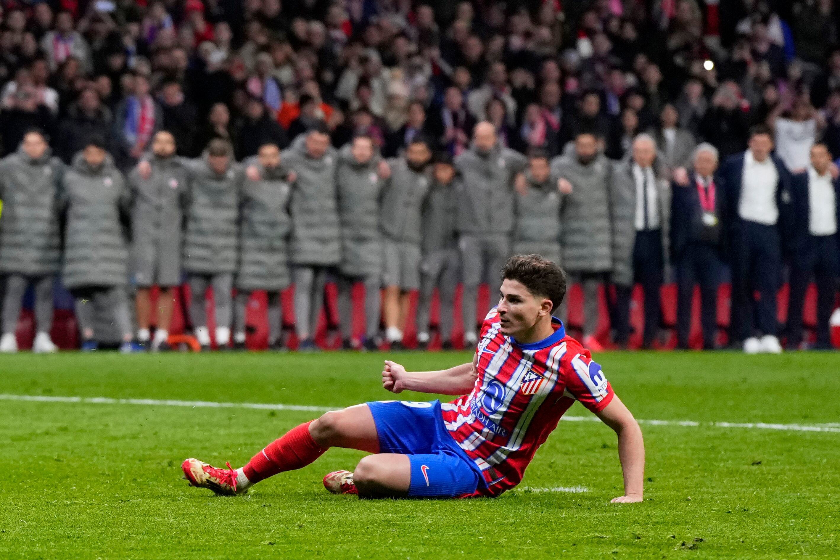 Julián Álvarez del Atlético de Madrid se resbala tras ejecutar un disparo en la tanda de penales ante el Real Madrid en los octavos de final de la Liga de Campeones, el miércoles 12 de marzo de 2025. (AP Foto/Manu Fernández)