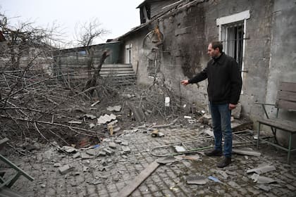 25-02-2022 Un hombre muestra el cráter de la explosión de un proyectil en su patio tras un reciente bombardeo, en Donetsk, República Popular de Donetsk. POLITICA Ilya Pitalev / Sputnik / ContactoPhoto
