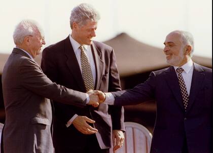 26 de octubre de 1994. El presidente estadounidense Bill Clinton aplaude mientras el rey Hussein de Jordania se acerca y le da la mano al primer ministro israelí Yitzhak Rabin (izq.) al final de la ceremonia de firma del tratado de paz entre Israel y Jordania - PBEAHUNIIEZ