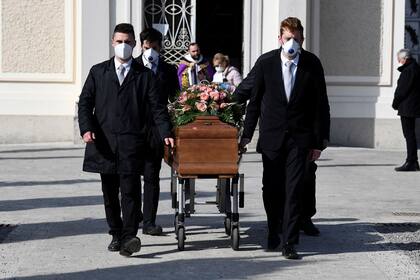 260/5000 Los portadores de féretros con máscaras protectoras llevan el ataúd de una mujer que murió de la enfermedad por coronavirus (COVID-19) en su funeral, mientras Italia lucha por contener la propagación de la enfermedad por coronavirus (COVID-19), en Seriate, Italia, 28 de marzo de 2020. REUTE