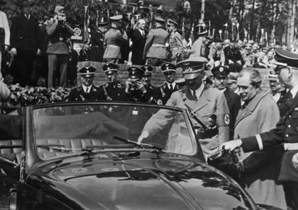 27 de mayo de 1938. Luego de colocar la piedra fundamental de la planta "Volkswagen", Adolf Hitler se retira del lugar en un Escarabajo junto al diseñador Ferdinand Porsche. (Photo by Topical Press Agency/Hulton Archive/Getty Images)