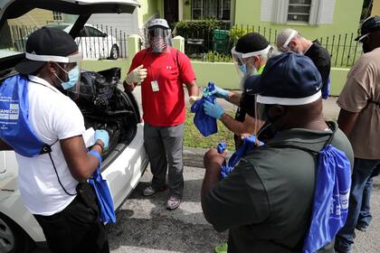 Morris Copeland, del grupo de centro de Respuesta Urbana Estratégica a la Educación de Orientación (SURGE), distribuye kits a los miembros del equipo que distribuirán a los residentes que viven en los puntos críticos de COVID-19, durante la nueva pandemia de coronavirus en Florida