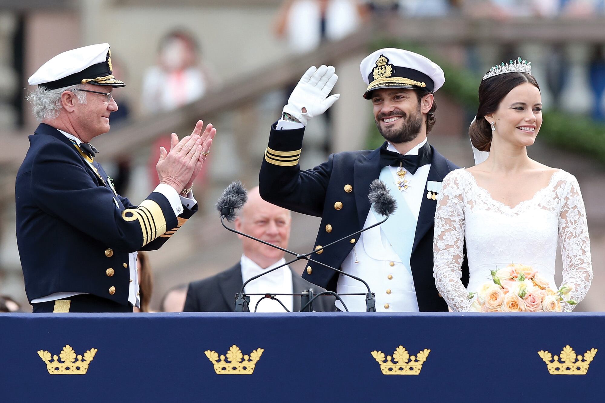 El rey Carlos Gustavo aplaude a su hijo, el príncipe Carlos Felipe, y a su flamante nuera, que saludan a la multitud después de la boda