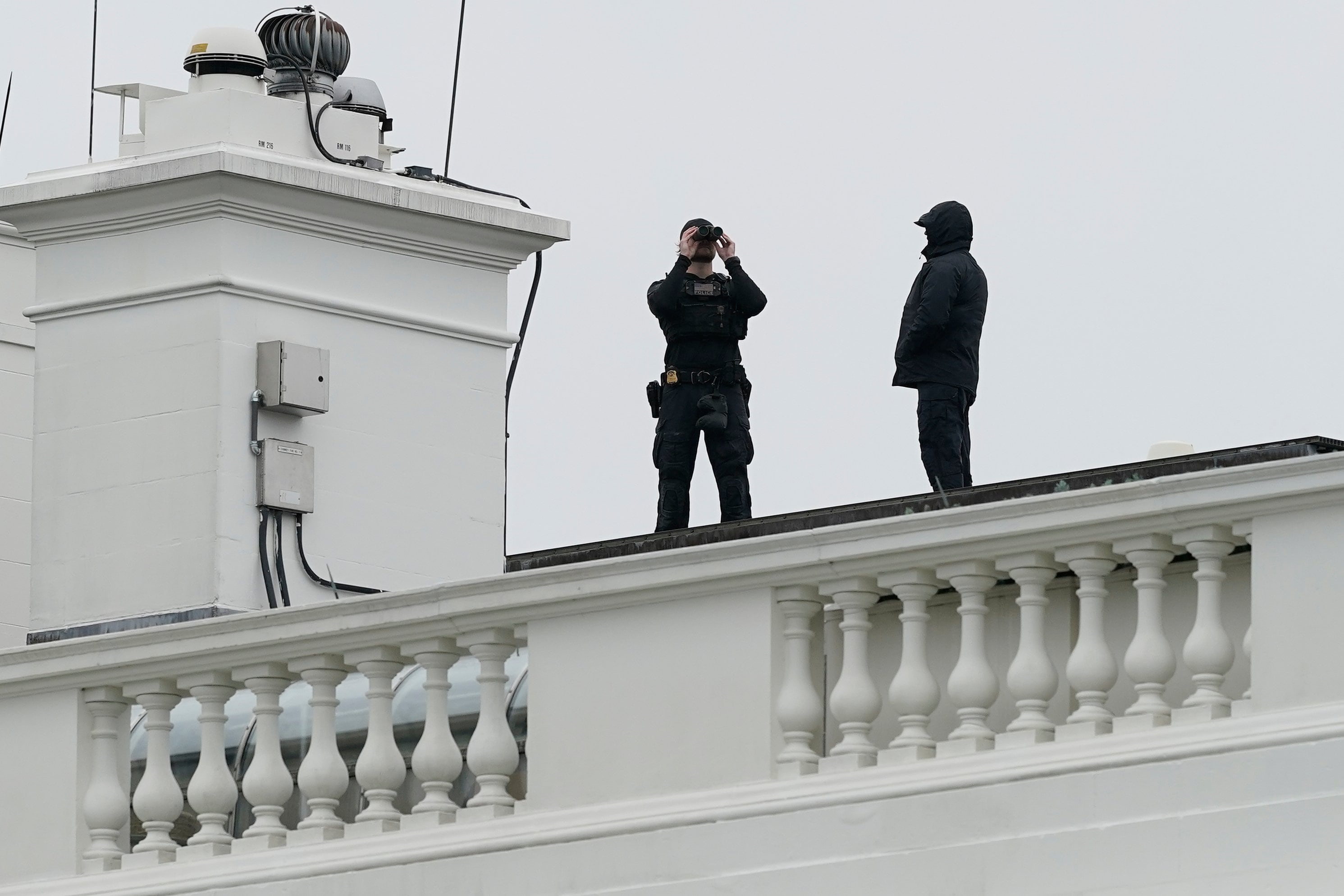 La policía del Servicio Secreto de Estados Unidos observa desde el techo de la Casa Blanca