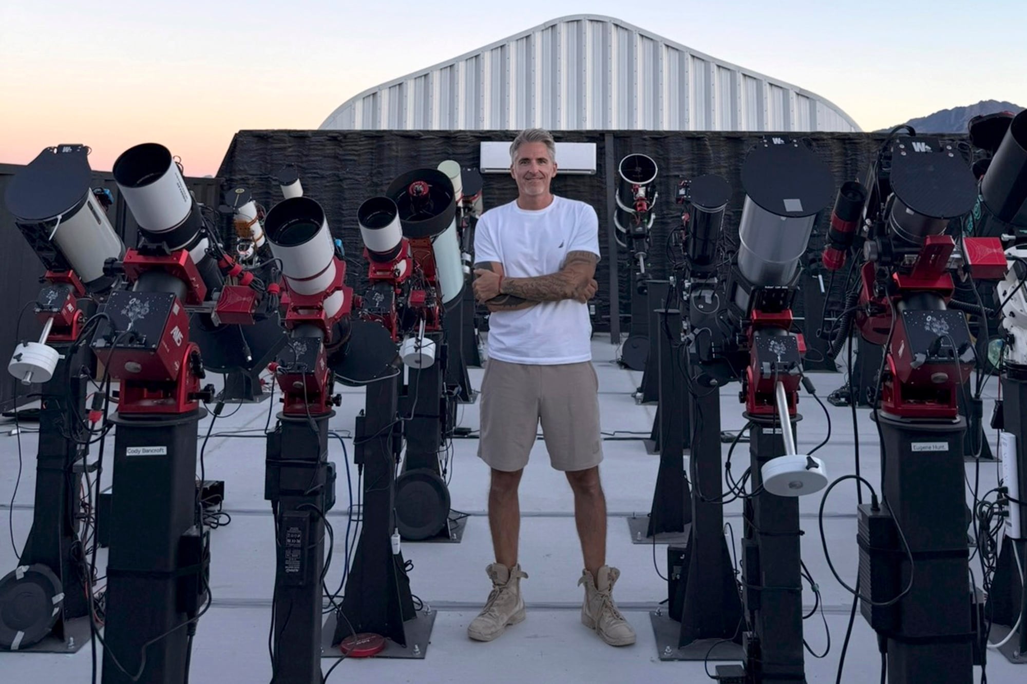 Nico posa en la granja de telescopios donde brinda un servicio de hosting por suscripción mensual. Cada cliente alquila un espacio para dejar instalado su telescopio y además, se le da soporte técnico, mantenimiento y acceso remoto