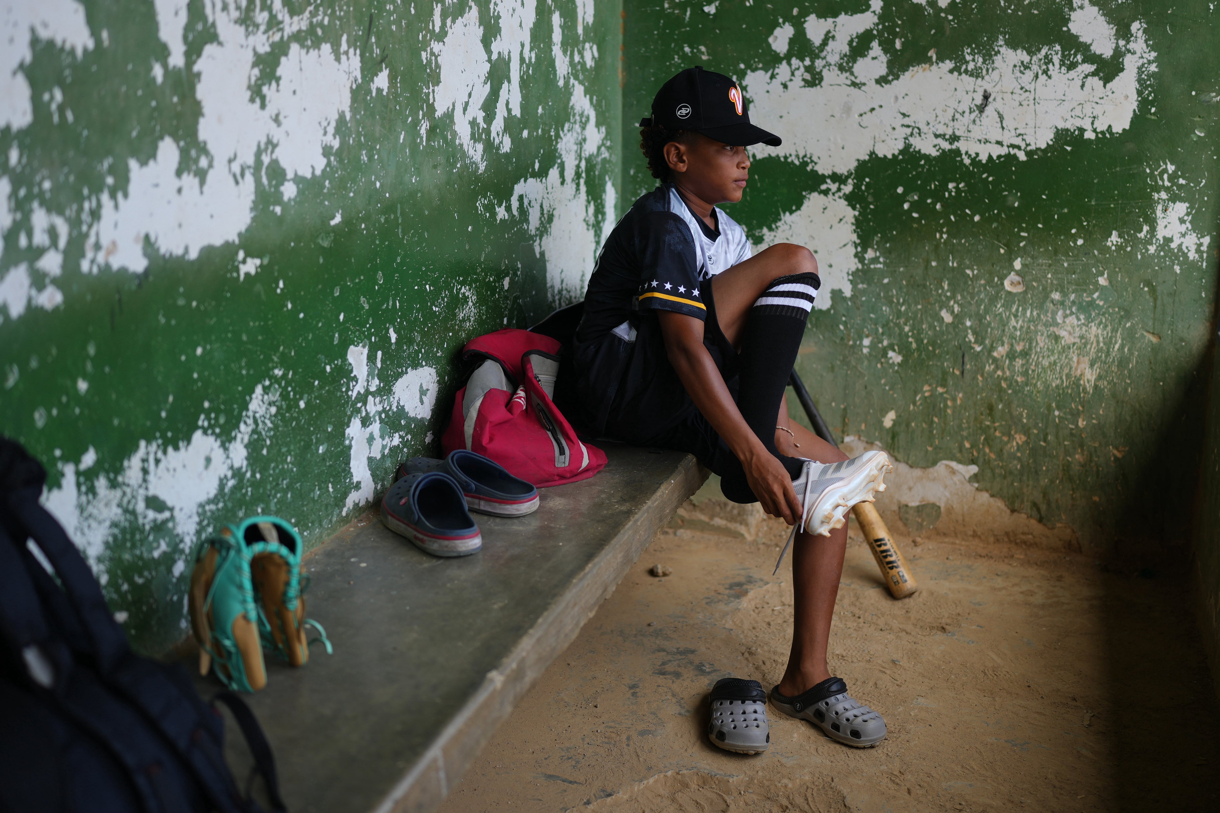 Yeferson Seijas se pone sus zapatos deportivos para un entrenamiento de béisbol en La Guaira