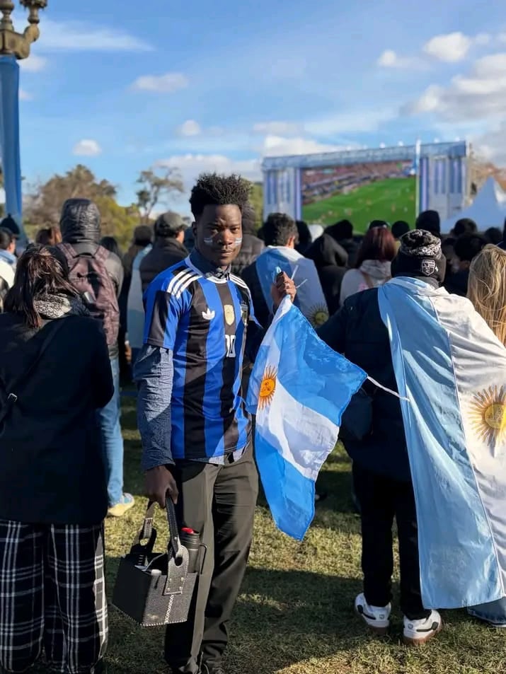 El haitiano John Thomasson Sylvinio en el fan fest con dos emblemas argentinos: la bandera y el mate