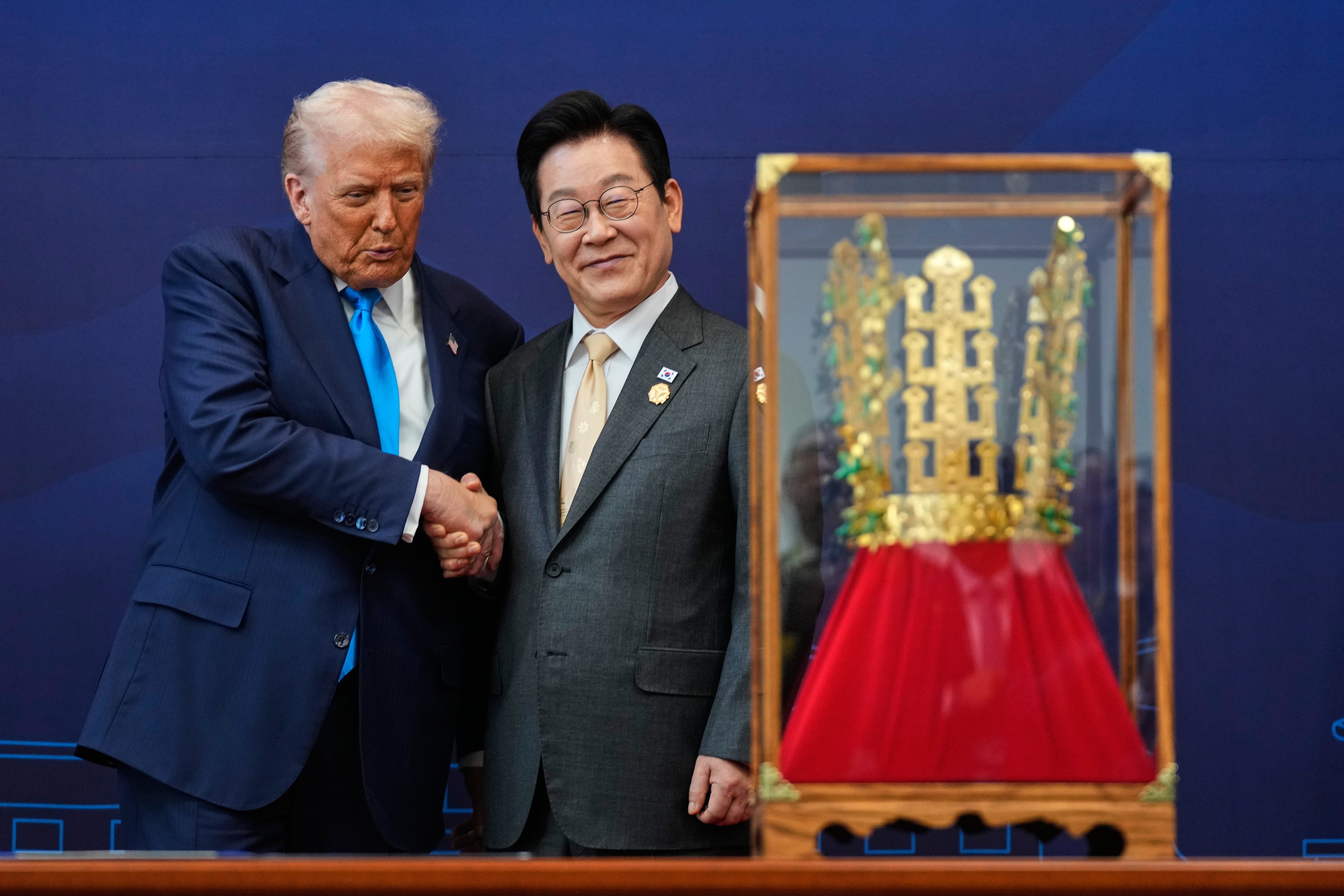 Donald Trump estrecha la mano del presidente surcoreano, Lee Jae Myung, mientras recibe un regalo consistente en una corona de oro y una condecoración de la Gran Orden de Mugunghwa, durante una ceremonia celebrada en el Museo Nacional de Gyeongju, en Corea del Sur, el 29 de octubre de 2025.