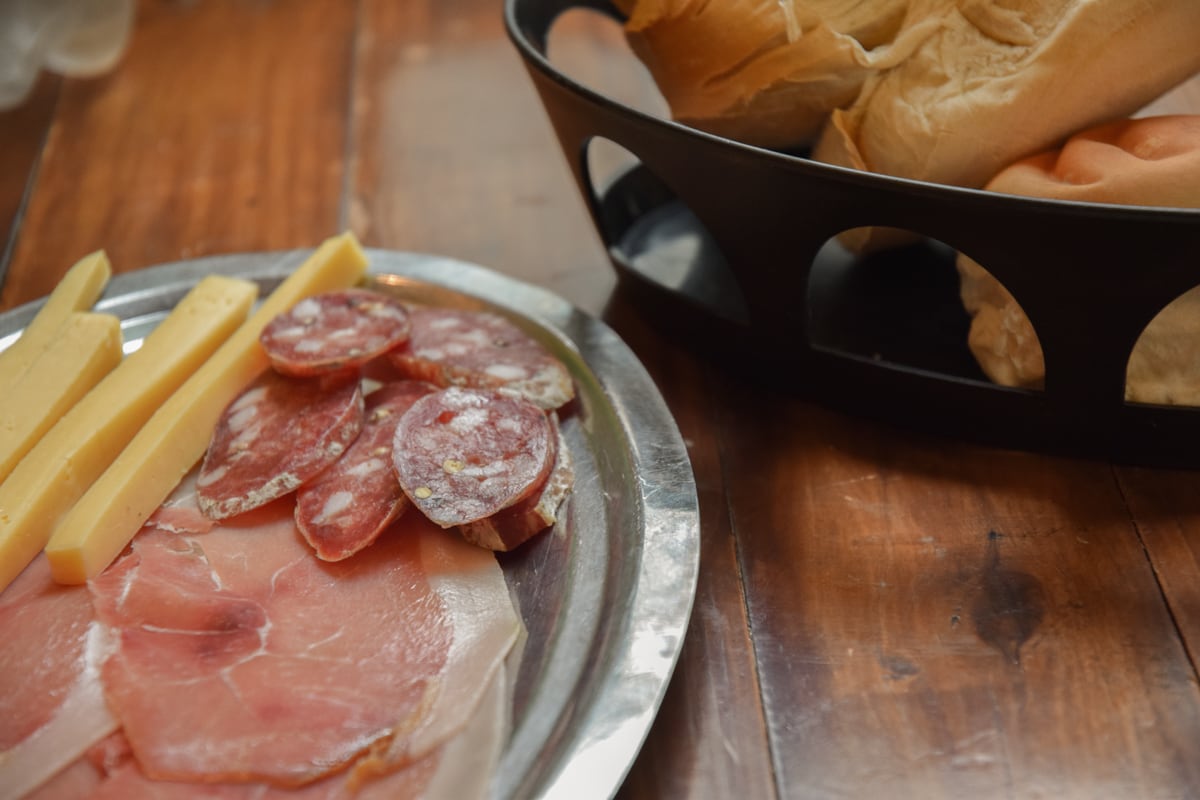 El menú incluye una tabla de fiambres y quesos de entrada (jamón crudo, salame quintero, queso y galleta de campo)