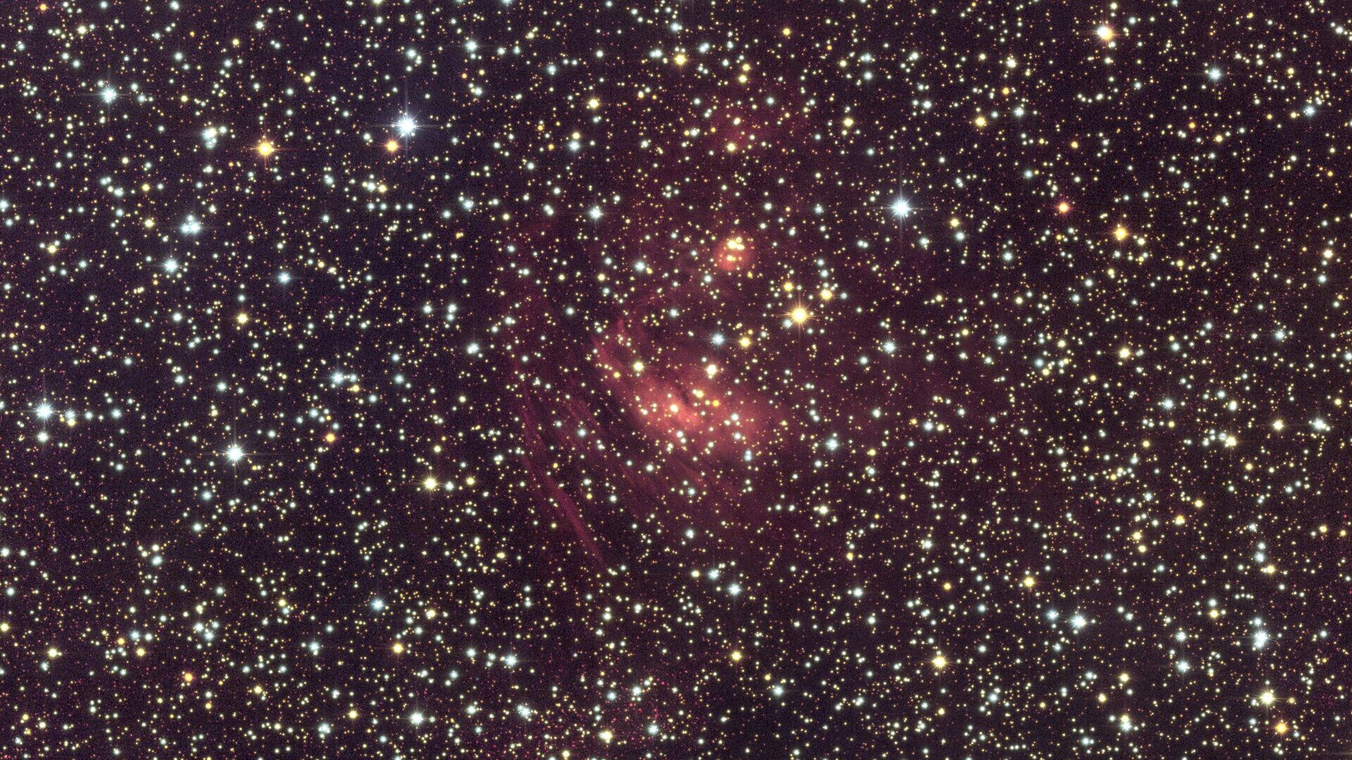 Región del centro de la galaxia donde se observan nubes de gas y polvo interestelar iluminadas entre miles de estrellas