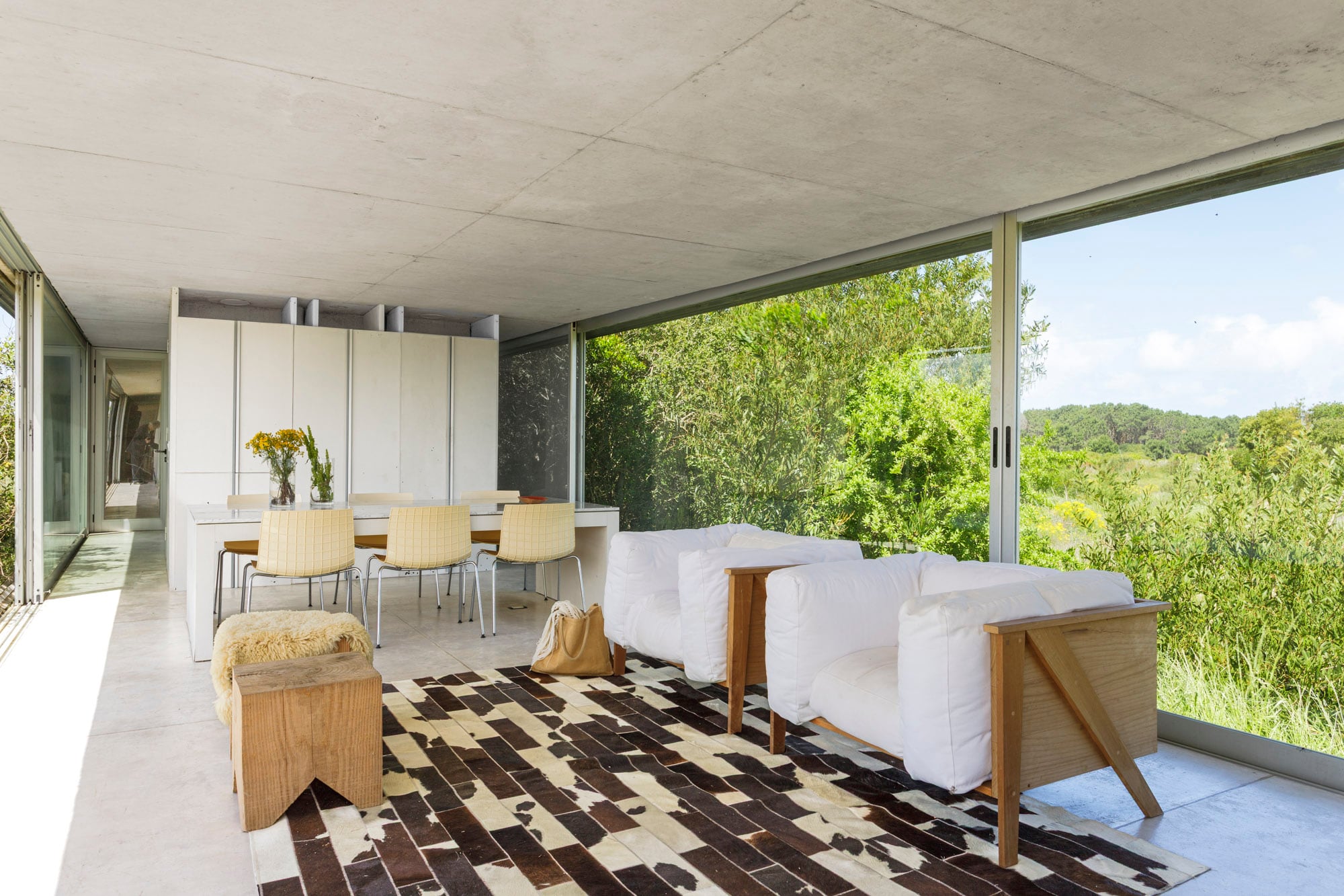 Marcelo Vila y Rocío Araujo proyectaron los sillones y encargaron los almohadones en una tienda de la localidad vecina de Rocha. Los bancos son cortes de eucalipto hechos en un aserradero