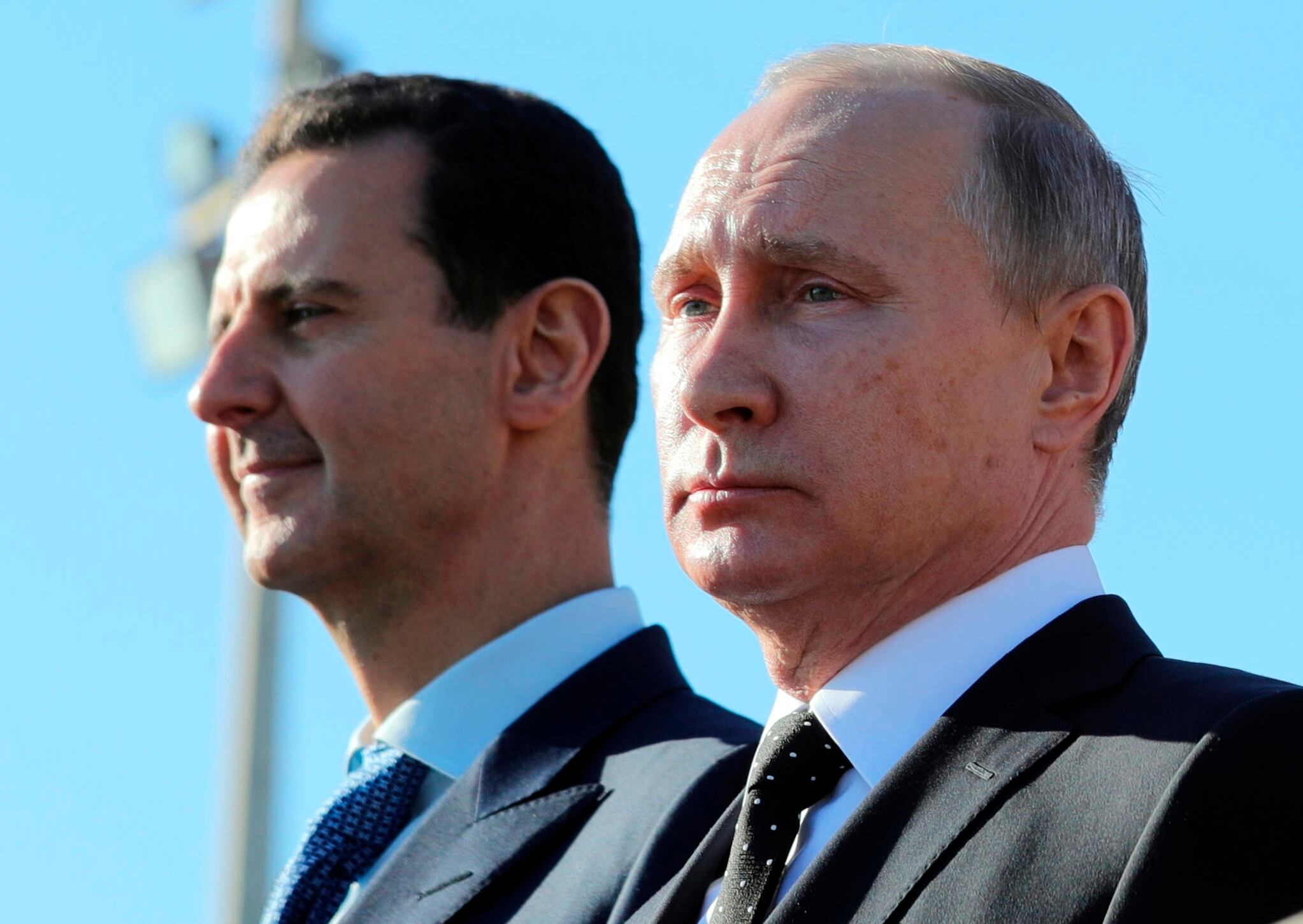 El presidente ruso, Vladimir Putin, y el entonces presidente sirio, Bashar al-Assad, observan la marcha de las tropas en la base aérea de Hemeimeem, en Siria, el 11 de diciembre de 2017. (Mikhail Klimentyev, Sputnik, Kremlin Pool Photo via AP, Archivo)