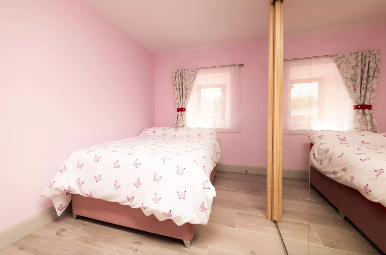 Una de las dos habitaciones de la propiedad, pintada de rosa y amueblada