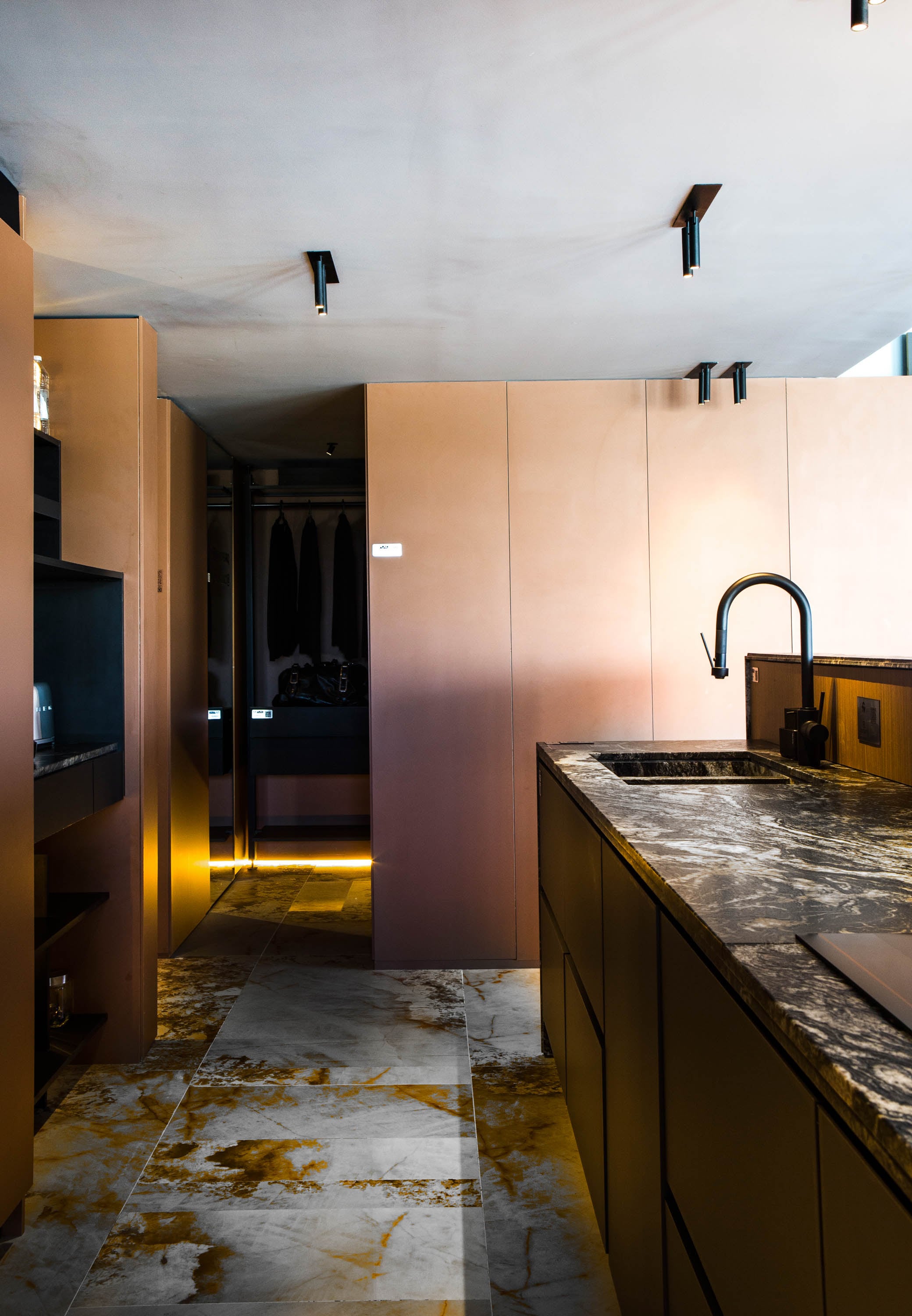 Yendo hacia el otro extremo de la cocina, nos dirijimos a los espacios privados. La bacha conformada está realizada con el mismo granito Amadeus (De Stefano) trabajado por Giannetta Mármoles. Grifería Augusta Pro en Black (FV).