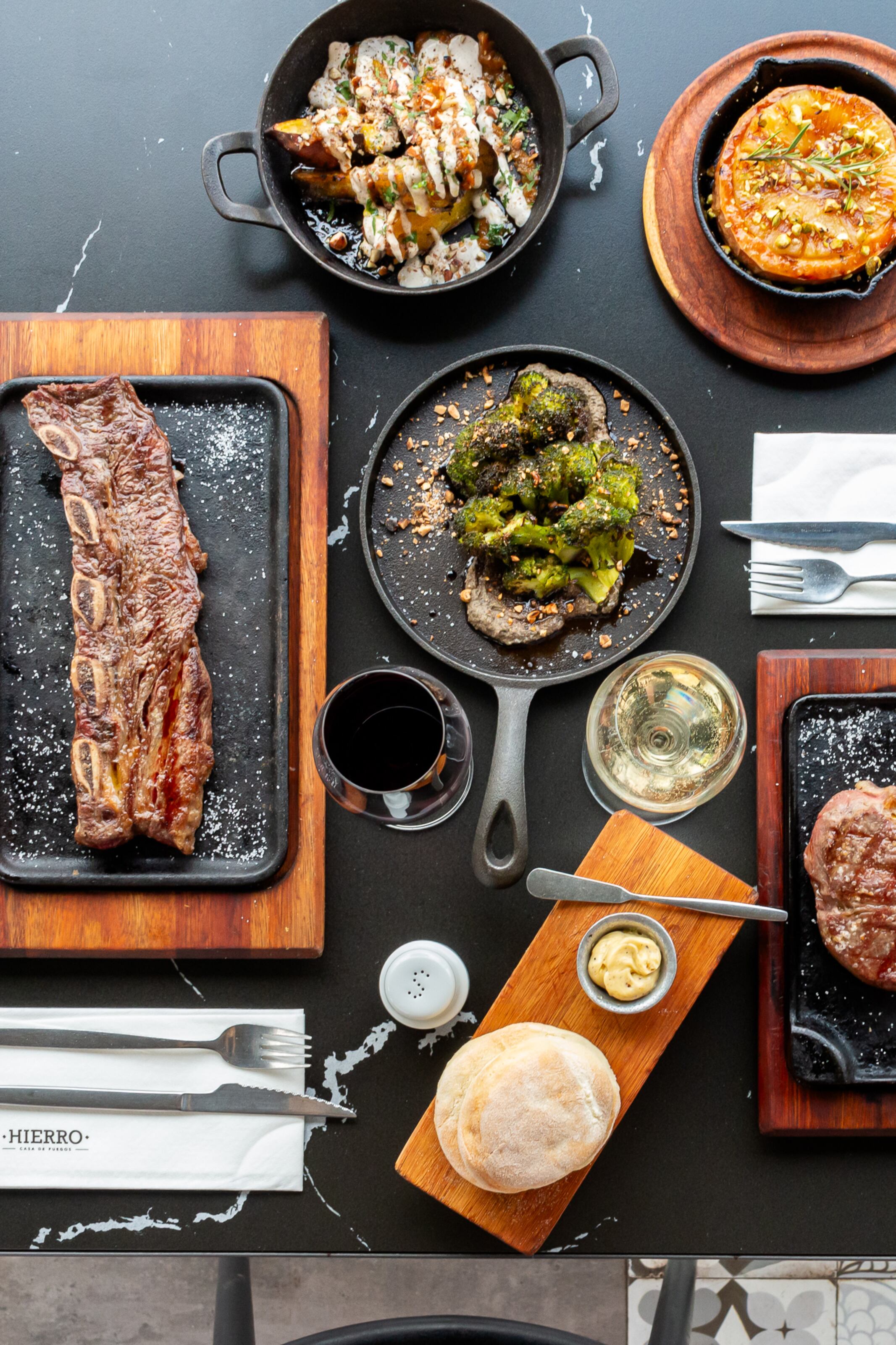 Empanadas de carne, cordero y humita se presentan junto a morcilla vasca y mollejas reinterpretadas, mientras la chuleta de berenjena frita y la provoleta con ananá grillado ofrecen su contrapunto vegetal