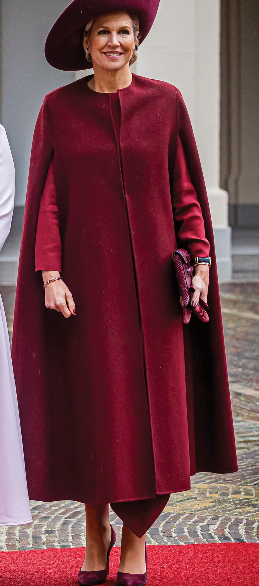 La Reina llevó un vestido manga larga y cuello redondo de Natan, capa de lana de Valentino, pamela de Fabienne Delvigne, sobre de piel de pitón de Sophie Habsburg y stilettos Gianvito Rossi