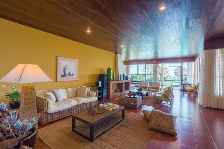 El living de la residencia refleja un diseño moderno y minimalista, con mobiliario de lujo y ventanales de piso a techo que maximizan la luz natural