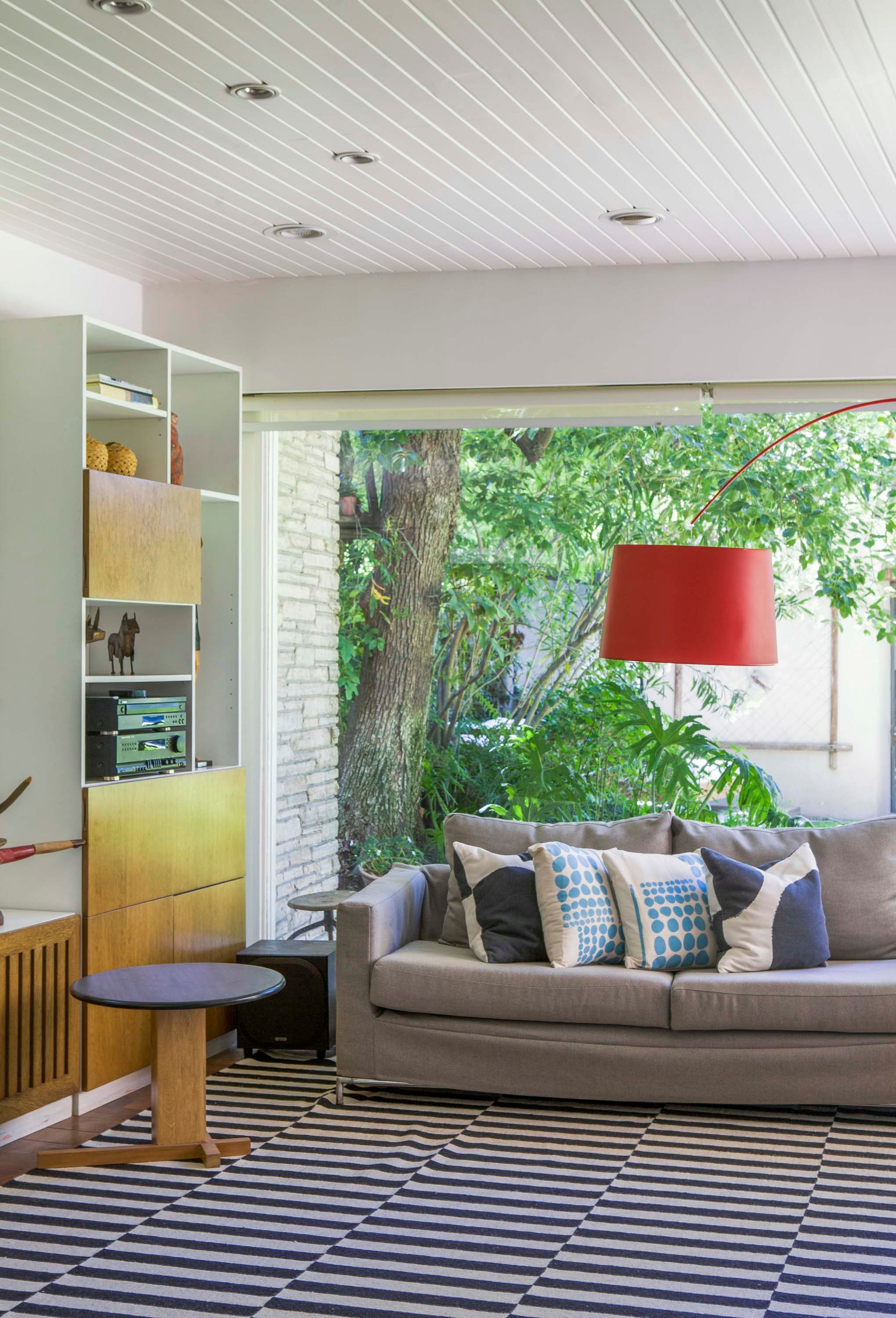 Luce súper actual, pero el techo revestido con listones de madera es original de la casa. Almohadones (Plaintextiles).