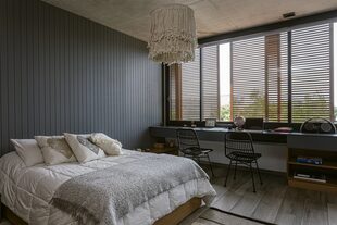 Ropa de cama y lámpara colgante (Guazu Nambi). Almohadones (Landmark). Alfombra (Elementos Argentinos). Fondo de cama en placas de MDF pintadas en gris grafito. Sillas de la firma italiana Kartell (Manifesto Design Store).