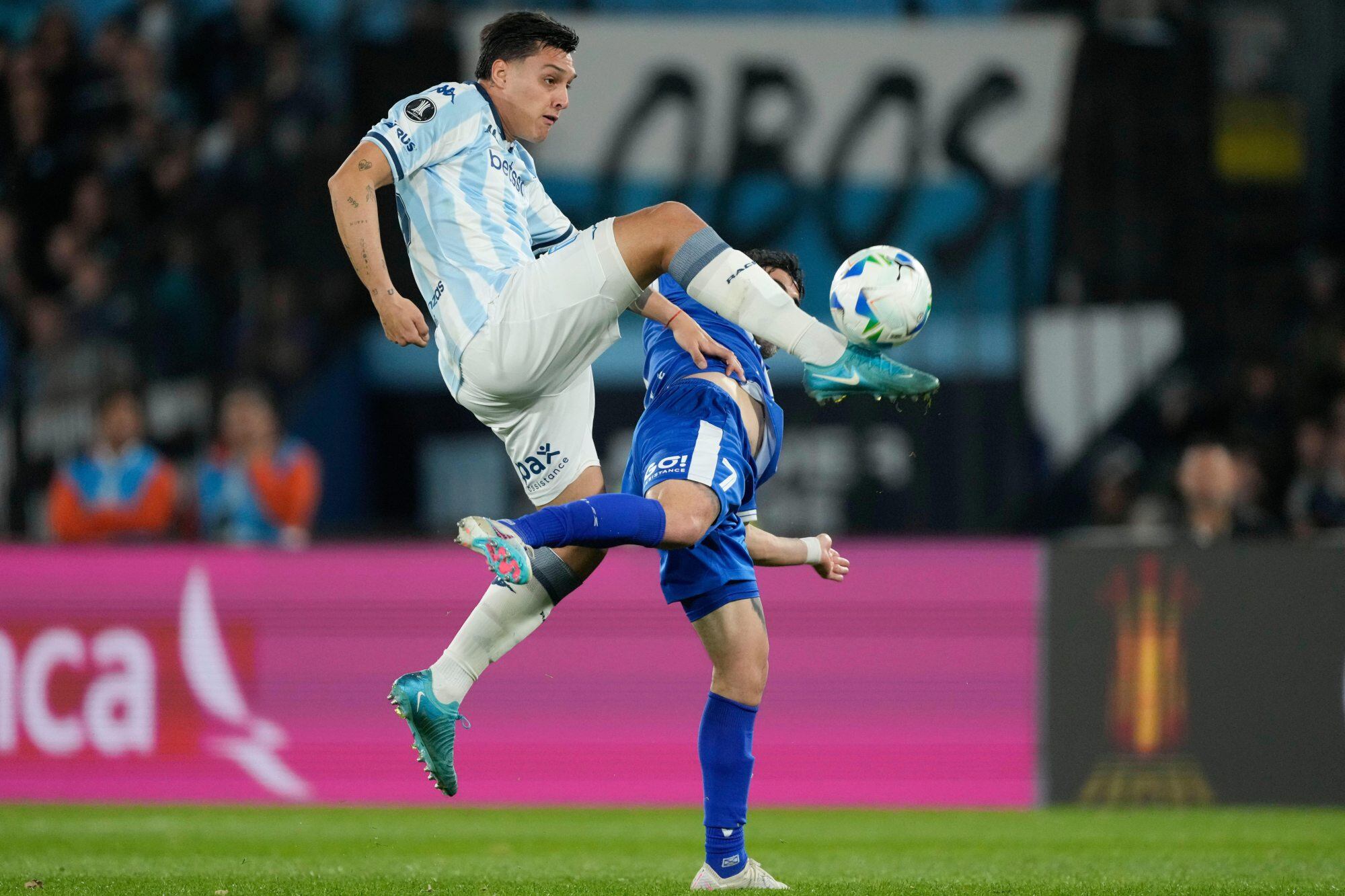 Nazareno Colombo of Argentina's Racing Club, left, jumps to control the ball beside Michael Santos of Argentina's Velez Sarsfield during a Copa Libertadores quarterfinal second leg soccer match at Presidente Peron stadium in Avellaneda, Argentina, Tuesday, Sept. 23, 2025. (AP Photo/Gustavo Garello)