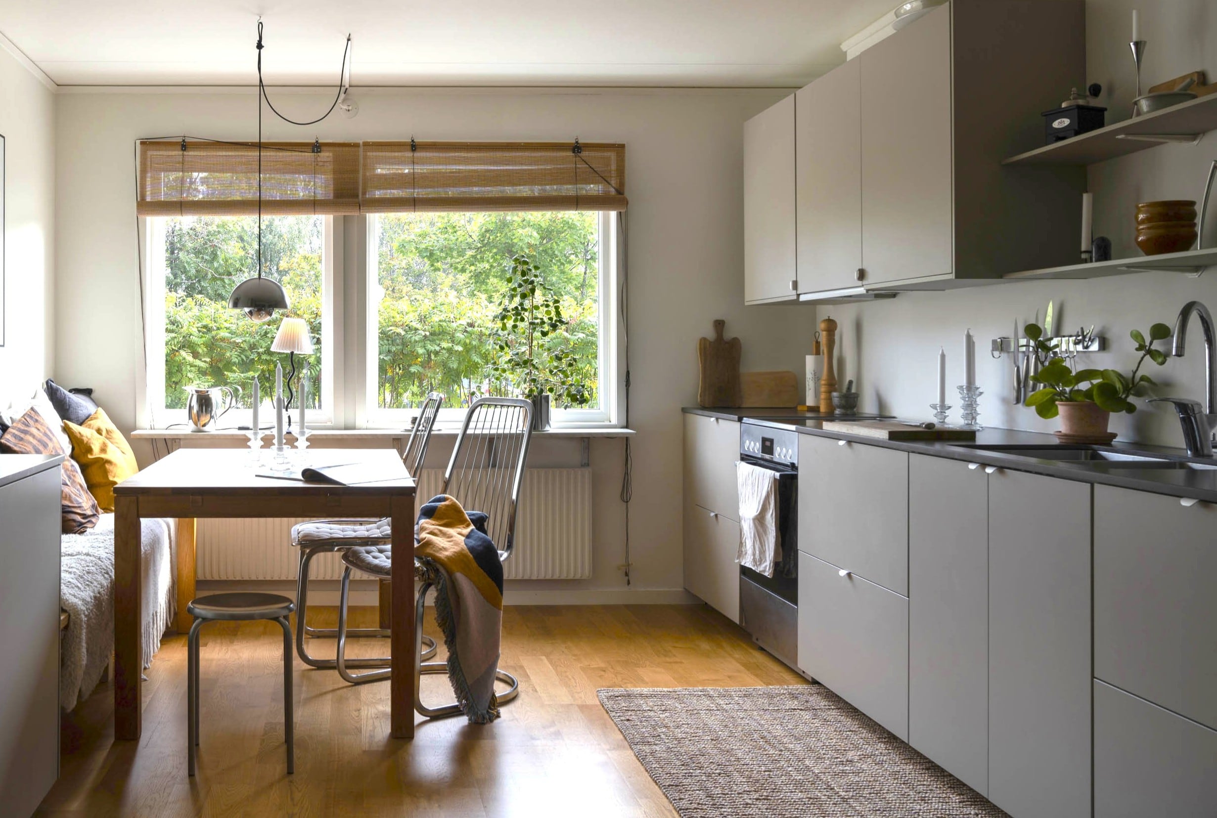 Un espacio que reúne cocina y comedor diario sobre el mismo piso de madera.