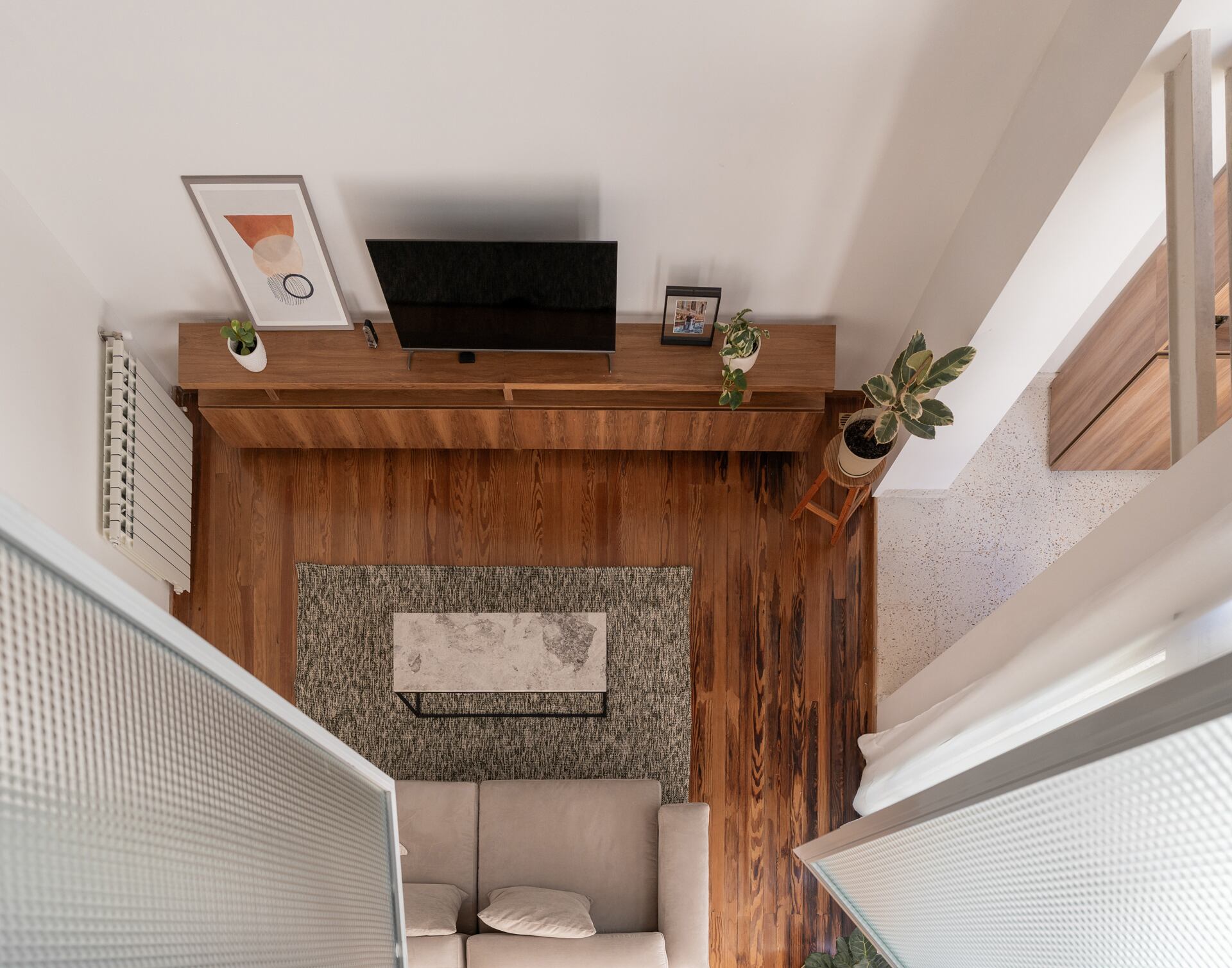 Vista desde la habitación superior hacia el living: la doble altura conecta visualmente los espacios, potenciando la sensación de amplitud y luminosidad.